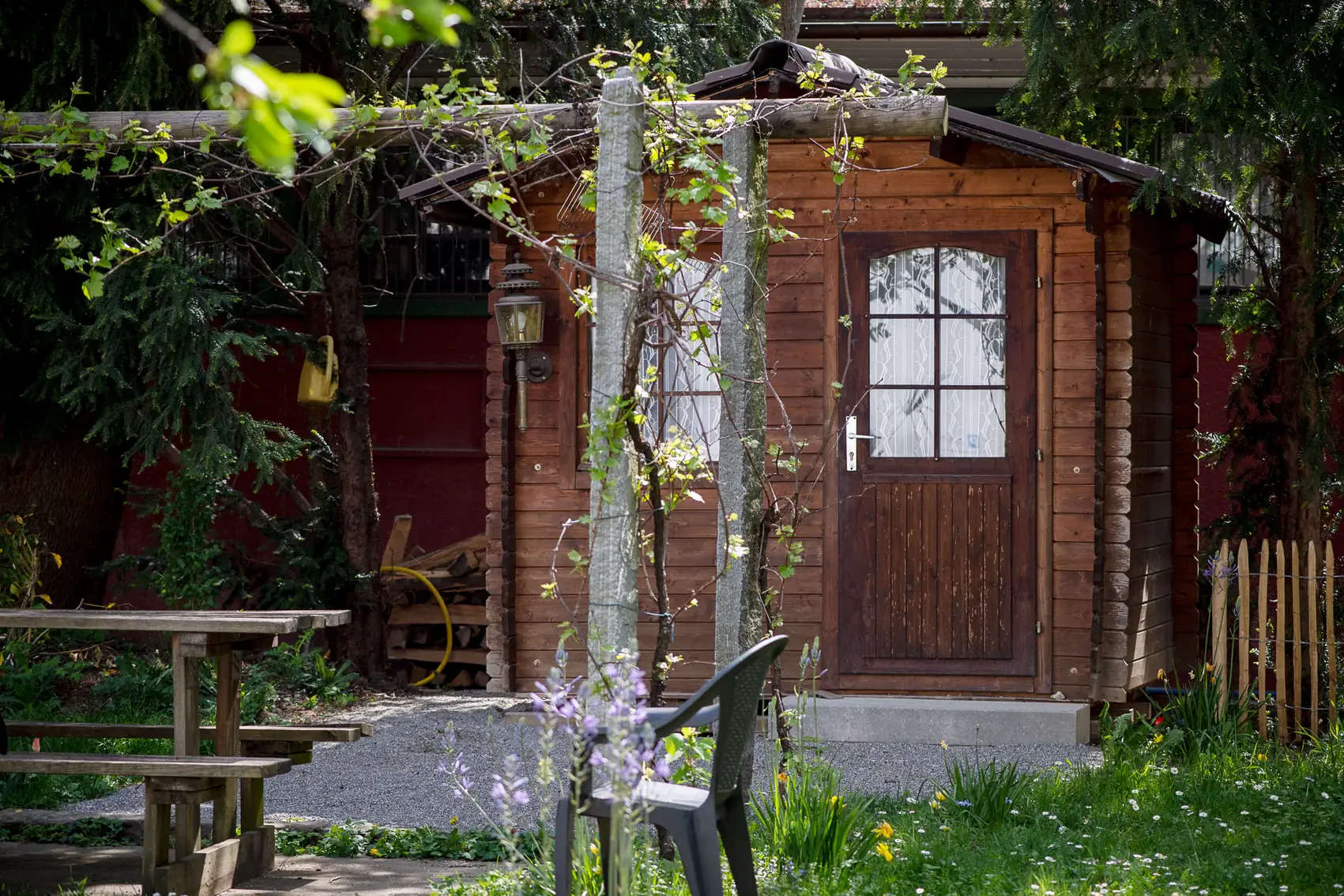 Gartenhaus mit berankter Pergola und Sitzplatz
